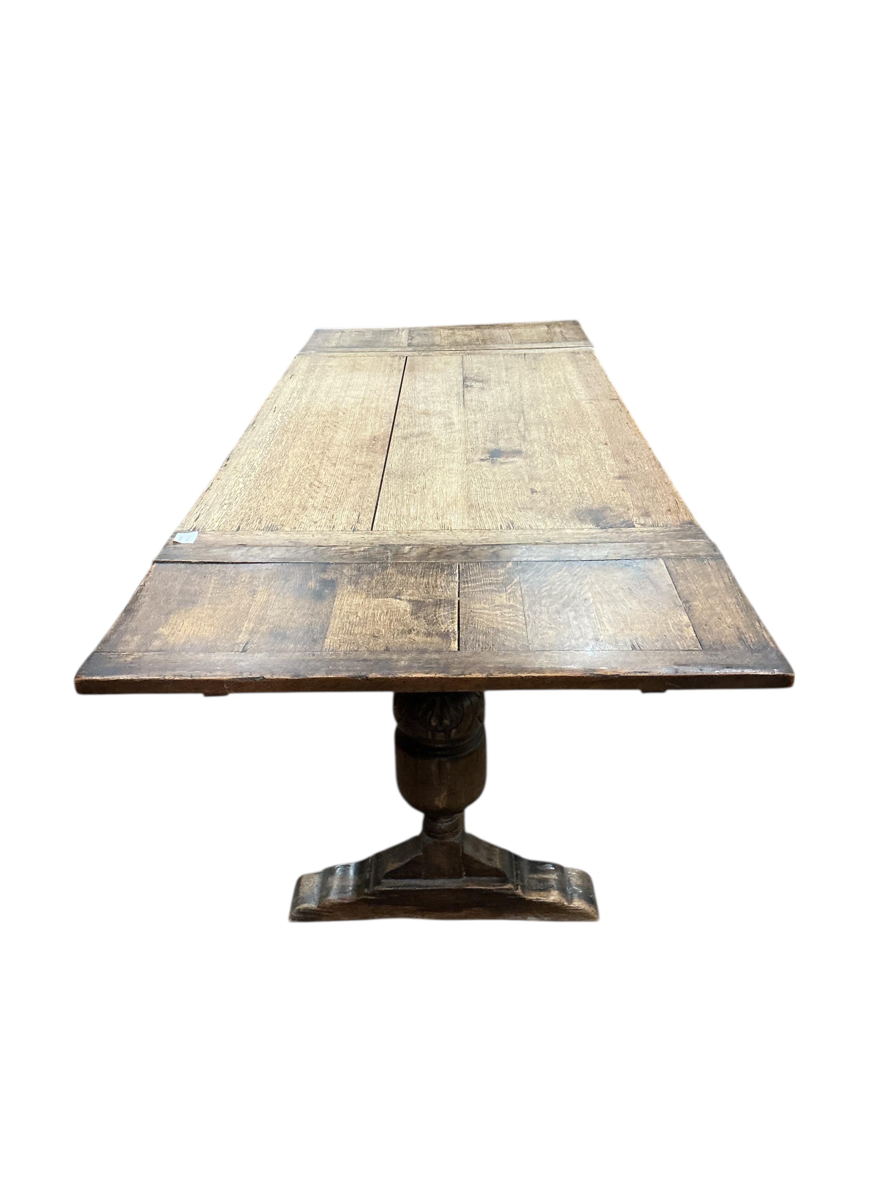 An 18th century style rectangular oak extending draw leaf refectory table, width 136cm, depth 80cm, height 78cm together with four carved oak dining chairs